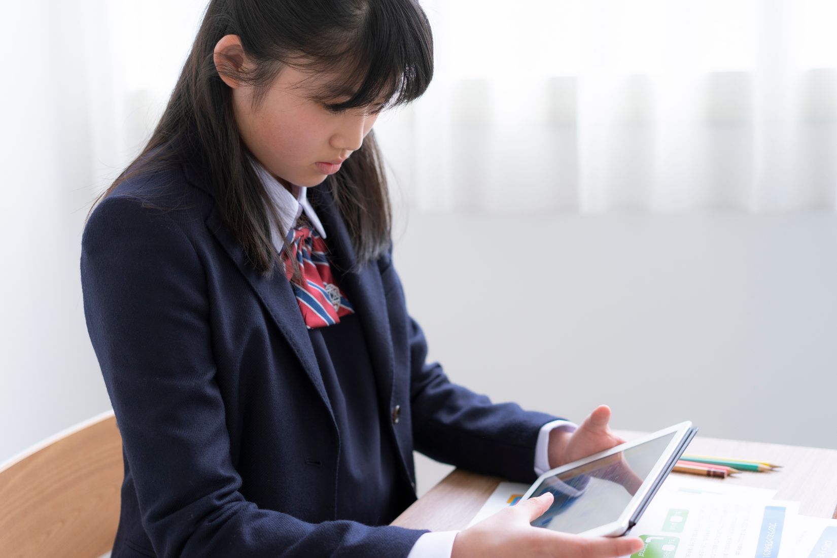 タブレットを見る女子学生のの写真